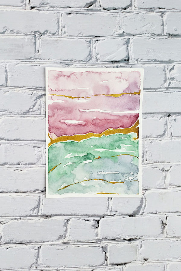 layered marble watercolor abstract on a white brick wall