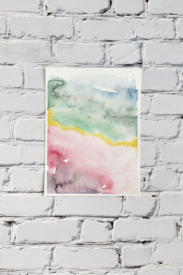 Marbled watercolor abstract print on a white brick wall